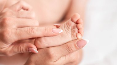 Bebek ayakları balkon arka planda kapanıyor. Hijyen reklamı, ayak hastalıkları, mantar, pedikür, ortopedi. Bebek için ayak masajı. Sağlık hizmeti kavramı.