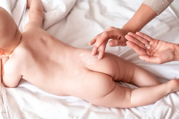 Annem banyodan sonra bebeğe losyon kremi sürüyor. Bebek bezini bebek odasında değiştiriyorum. Bebek için masaj. konsept temizlik, saf, temiz.