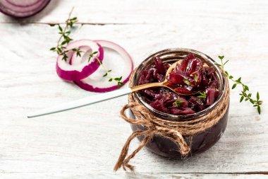 Ev yapımı kırmızı soğan reçeli, konfeksiyon, kırsal ahşap bir masada kavanozda turşu. Lezzetli sos. Fransız mutfağı..