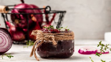 Ev yapımı kırmızı soğan reçeli, konfeksiyon, kavanozda turşu. Beyaz ahşap arka planda sebze reçeli. Uzun afiş biçimi. Metin için boşluk.