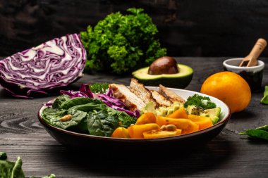 Mor lahana, avokado, ıspanak, domates, fileto ve fındıklı taze salata. Keto Paleo öğle yemeği. Sağlıklı beslenme konsepti.