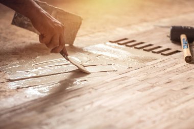 Marangozun ellerini kapat ya da odaya parke, kaplama ya da parke için uygulamalı yapıştırıcı koy..