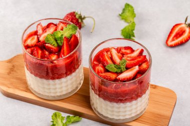 Geleneksel İtalyan tatlı panna cotta ve çilekli jöle. Yazlık yoğurt tatlısı. Yemek tarifi geçmişi. Kapat..