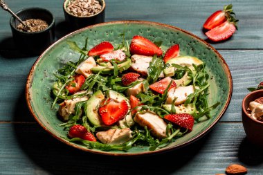 Taze çilek salatası, roka, tavuk, avokado ve çilek. Keto diyet yemekli tabak. Üst görünüm.