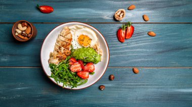 Tavuk, roka ve çilekli Buda kasesi. Keto diyet yemek tarifi geçmişi. Uzun pankart biçimi, üst görünüm.