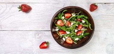 Diyet menüsü. Sağlıklı taze çilek salatası, roka, ricotta ve bir kasede tohum. Vejetaryen yemeği. Düz yatıyordu. Pankart. Üst görünüm.