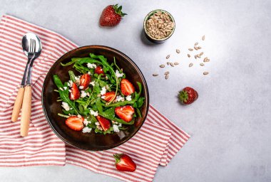 Diyet menüsü. Sağlıklı taze çilek salatası, roka, ricotta ve bir kasede tohum. Vejetaryen yemeği. Düz yatıyordu. Pankart. Üst görünüm.