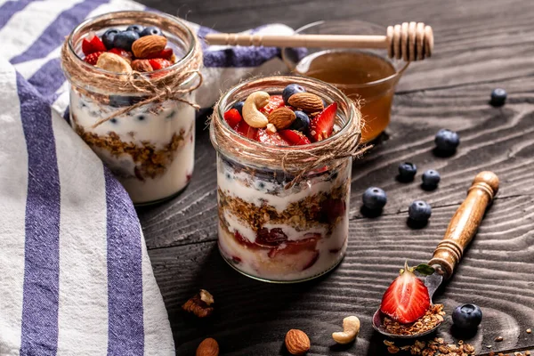 Dietary menu. Healthy vegan Breakfast from fresh natural yogurt with homemade granola and blueberries strawberry in glass jar. banner menu recipe, top view.