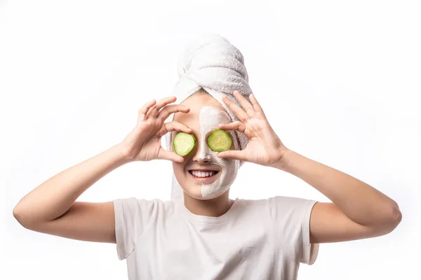 快乐的小女孩戴着毛巾 脸上戴着面具 眼睛上戴着黄瓜 她的美感越来越强烈 温泉治疗的概念 — 图库照片