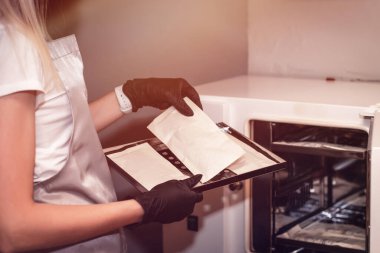 Çalışan manikür aletinin steril temizliği için ekipman. Süreç steril kıyafet manikür ustası bir hemşire tarafından gerçekleştiriliyor. Metin için boşluk,