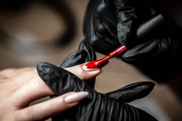 Manicurist Hand Painting Client\'s Nails. Manicure care procedure, Close-up photo Of Beautician Hand Filing Nails Of Woman In Salon.