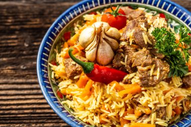 Pilav denilen geleneksel Özbek yemeği. Etli pilav, havuçlu ve soğanlı tabakta doğu süsü, Özbek doğu mutfağı. en üstteki görünüm.