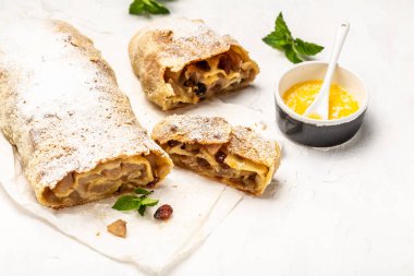 Evde sonbahar, yaz pişirme, puf böreği. Elmalı turta, kuru üzüm, tarçın ve arkaplanda nane şekeri. Yukarıdan görünüm, pankart biçimi, üst görünüm.