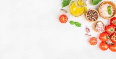 Taze domates, sarımsak, fesleğen, zeytinyağı ve beyaz arka planda baharatlar. Uzun afiş biçimi. Üst Manzara. Boşluğu kopyala.