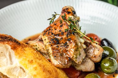 Zeytin, domates ve kızarmış ekmekle ızgara balık filetosu..