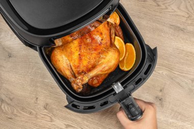 Ahşap masada portakallı tam kavrulmuş tavuk, üst manzara, yazı için boş yer..