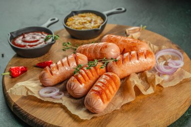 Ahşap tahtada soslu ve baharatlı ızgara sosisler. Kapatın, boşluğu kopyalayın..