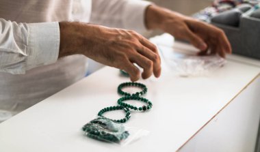 Dükkanında çalışan kuyumcu elleri değişik tipte bilezikler düzenliyor..