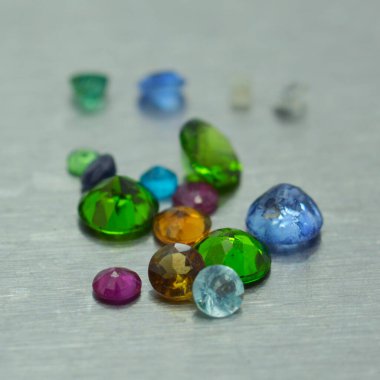 Metal yüzeyde farklı renkte ve şekillerde değerli taşlar var.