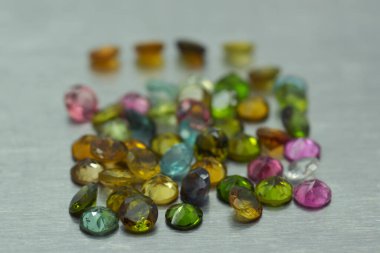 Metal yüzeyde farklı renkte ve şekillerde değerli taşlar var.