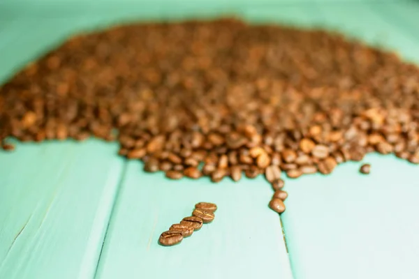 青緑色の背景に黒のコーヒー豆 — ストック写真