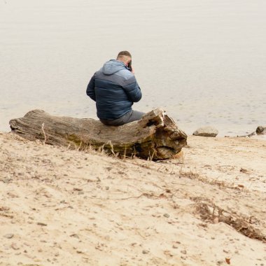 Genç adam telefonda konuşuyor.