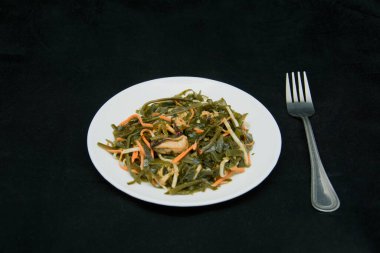 Siyah arka planda bir tabakta deniz lahanası