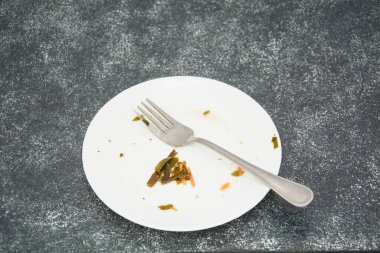 Koyu arkaplanda yemek artıkları olan tabak.