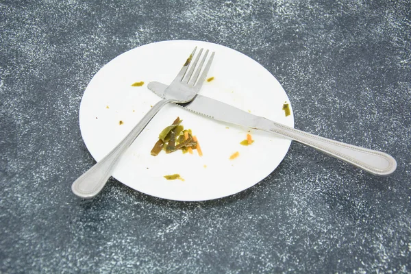 Plate with leftover food on dark background