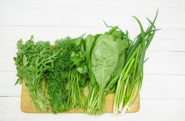 Arugula, ıspanak, dereotu, hafif arka planda maydanoz.