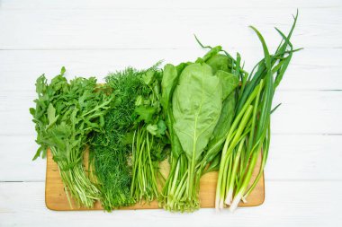 Arugula, ıspanak, dereotu, hafif arka planda maydanoz.