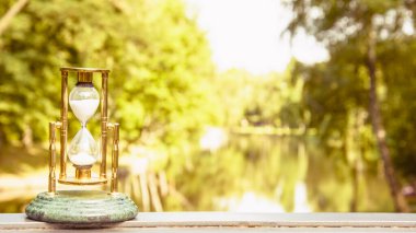 Güzel kum saati, güzel doğanın arka planında duruyor.