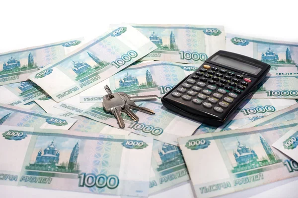 Калькулятор і ключі від квартири на банках грошового ряду та концепції іпотеки — стокове фото