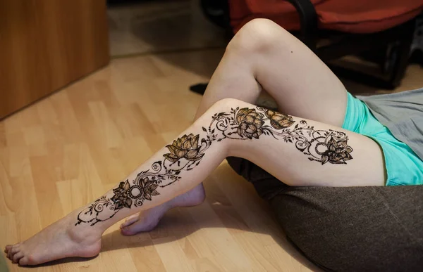 Henna tattoo design on legs. Beautiful indian mehendi ornaments painted on a body part