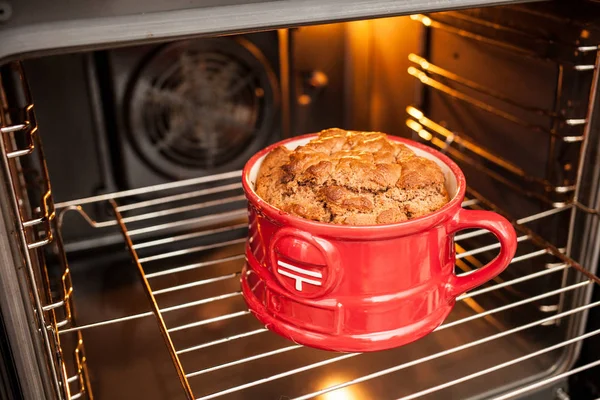 chocolate caramel Cake in a red mug cooked in the oven.