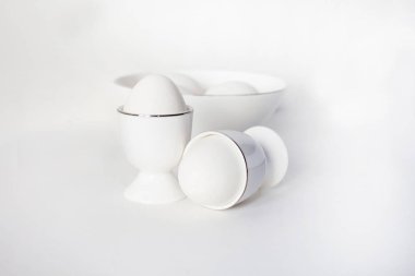 Beyaz yumurta yumurta için bir stand ve bir kase beyaz zemin üzerine kapatın. sağlık gıdalar kilo kaybı ve kas kazanç için