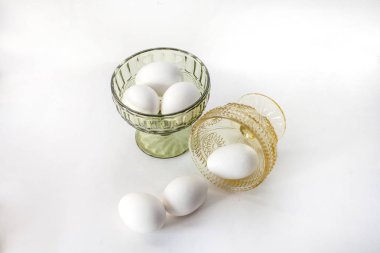 Beyaz yumurta yumurta için bir stand ve bir kase beyaz zemin üzerine kapatın. sağlık gıdalar kilo kaybı ve kas kazanç için