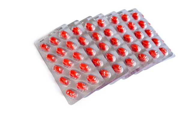 Embalagem de comprimidos vermelhos isolado no fundo branco — Zdjęcie stockowe