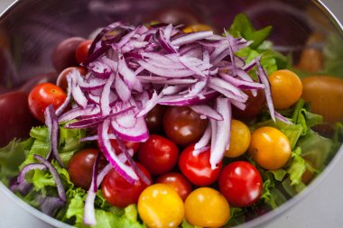 Taze salata rucola, kiraz domates, beyaz peynir ve bir kase içinde kırmızı soğan ile. Üstten Görünüm