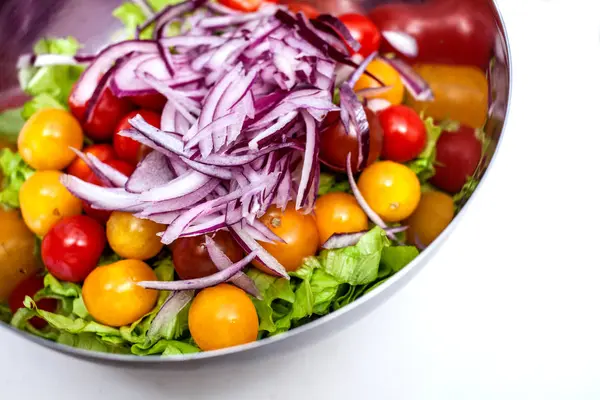 Salada fresca com rucola, tomate cereja, queijo feta e cebola vermelha em uma tigela. vista superior com espaço de cópia — Fotografia de Stock