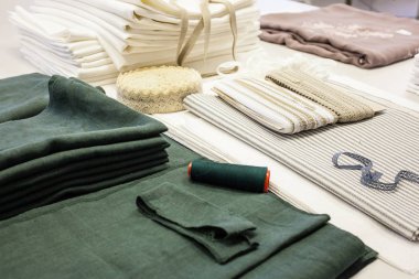 Terzi işyeri yeşil ve beyaz keten kumaş ve dantel örnekleri ile üretimde masaya yatırılır