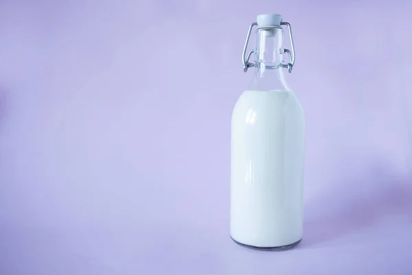 Frische Milch zum Frühstück in einer Glasflasche auf Lavendelgrund — Stockfoto