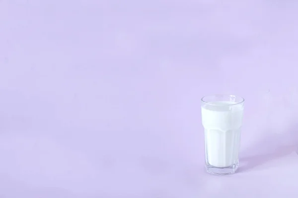 Glas verse melk op een lavendel achtergrond — Stockfoto