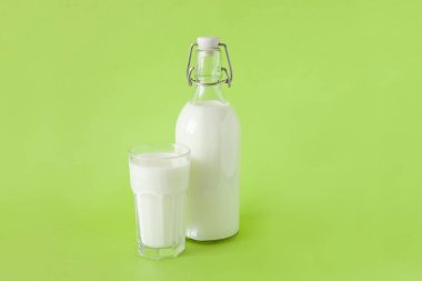 bir şişe süt ve yeşil bir arka plan üzerinde süt bir bardak