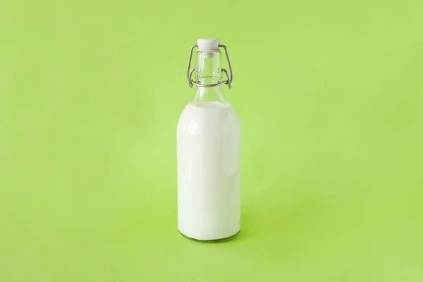 Melk in een flesje op een licht groene achtergrond — Stockfoto