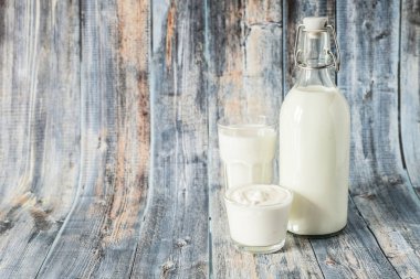 Süt kefir ve ekşi krema ahşap bir arka plan üzerinde bir satır bulunmaktadır. Kahvaltı için taze süt ürünleri