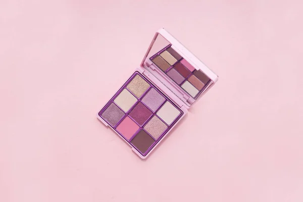 Pohled shora Paleta Růžové kosmetiky s zrcadlem na růžovém pozadí, minimalismus barevných stínů, na světle růžovém pozadí — Stock fotografie