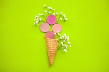 Güzellik ve moda kavramı. yeşil bir arka plan üzerinde dondurma için bir koni içinde gypsophila ile yuvarlak pembe allık
