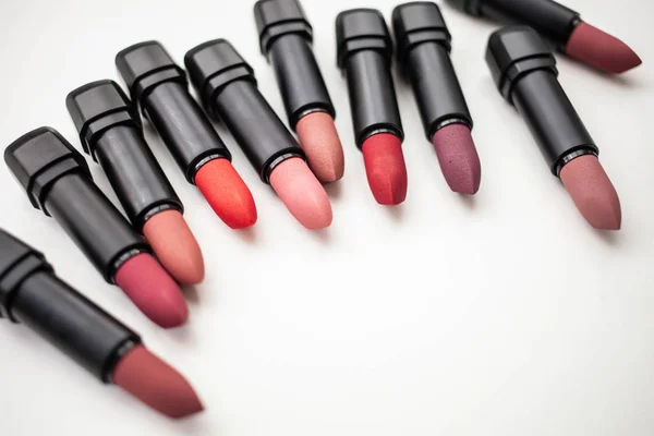 Lipstick in different natural colors on a white background. Top view copy space — Stock Photo, Image