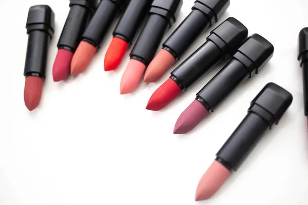 Lipstick in different natural colors on a white background. Top view — Stock Photo, Image